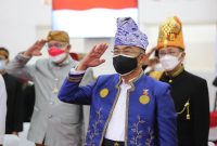Menko PMK Muhadjir Effendy mengenakan pakaian adat Tanah Bumbu dalam upacara peringatan HUT RI ke-76 secara virtual, didampingi para pejabat Eselon 1 dan 2 di Kantor Kemenko PMK, Jakarta, Selasa, (17/08/2021). (Foto: Pelopor/Kemenko PMK)