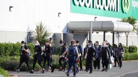 Seorang petugas polisi membawa karyawan toko menjauh dari lokasi serangan yang dilakukan oleh seorang pria di pusat perbelanjaan di Auckland, Selandia Baru, (3/9/2021). (Foto: Stuff Limited/Ricky Wilson/Reuters)