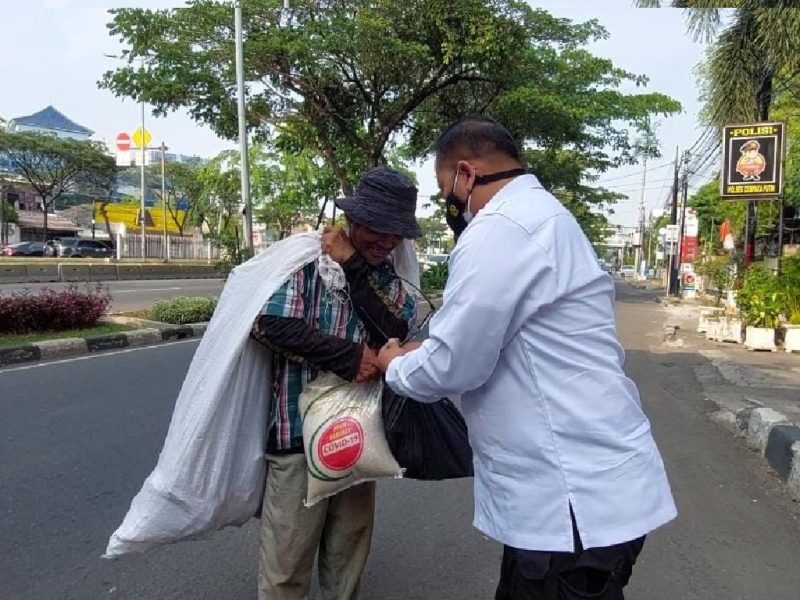 Ketua Presidium ICPW Bambang Suranto membagikan sembako langsung kepada masyarakat kurang mampu. (Foto:Pelopor.id/ICPW)