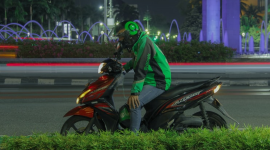 Seorang supir Gojek berhenti di pinggir jalan. (Foto: Pelopor/Unsplash)