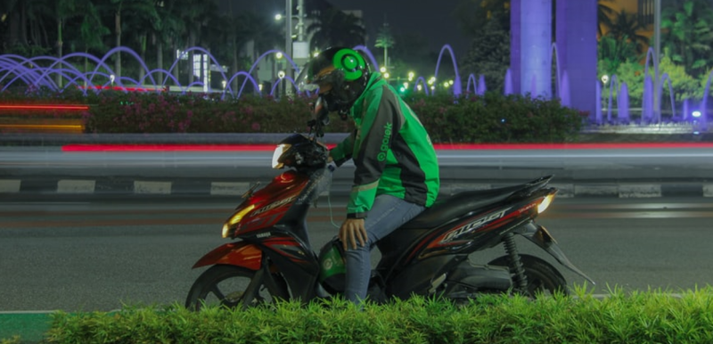 Seorang supir Gojek berhenti di pinggir jalan. (Foto: Pelopor/Unsplash)