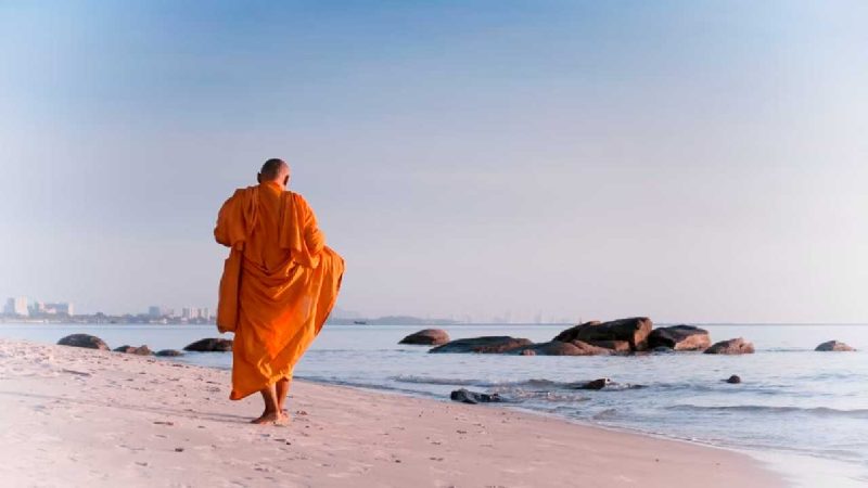 Seorang biksu berjalan di pantai di Distrik Hua Hin. (Foto: Pelopor.id/Unsplash/Thomas Oxford) 