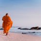 Seorang biksu berjalan di pantai di Distrik Hua Hin. (Foto: Pelopor.id/Unsplash/Thomas Oxford) 
