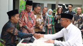 Menteri Koordinator Bidang Pembangunan Manusia dan Kebudayaan (Menko PMK) Muhadjir Effendy menyerahkan zakat di Taman Masjid Nurussalam Kemenko PMK pada Jumat (14/3/2023). (Foto:Pelopor.id/Kemenko PMK)